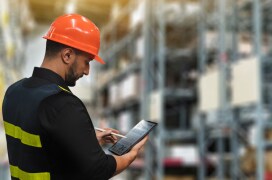 Un employé examine un rapport d’inventaire sur une tablette dans un entrepôt. Un employé examine un rapport d’inventaire sur une tablette dans un entrepôt.